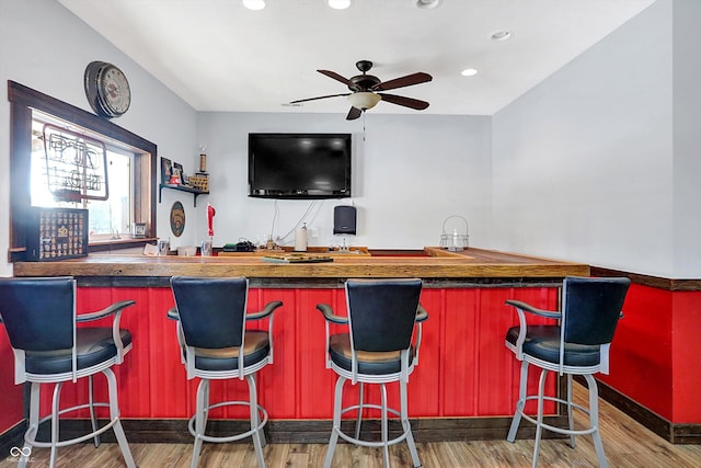 bar with hardwood / wood-style flooring and ceiling fan