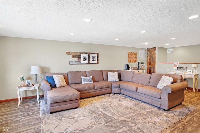 living room with wood-type flooring and a textured ceiling