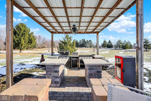 view of patio featuring an outdoor kitchen, an outdoor bar, and ceiling fan