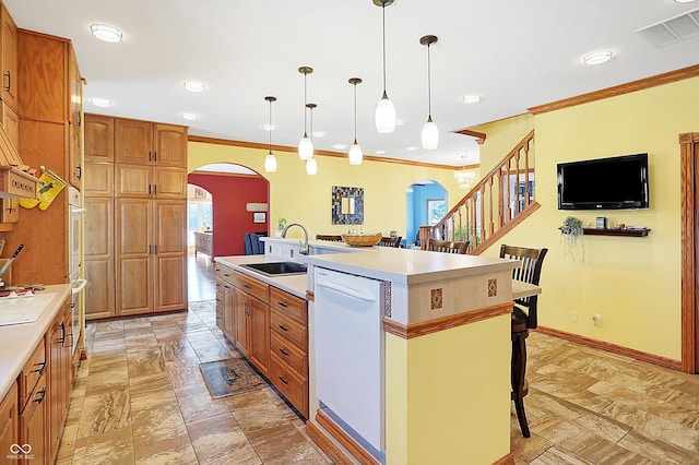 kitchen with a breakfast bar, pendant lighting, an island with sink, sink, and white appliances