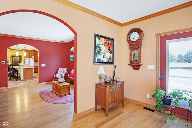 entryway featuring crown molding and light wood-type flooring