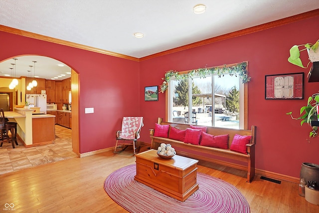 living room with ornamental molding and light hardwood / wood-style flooring