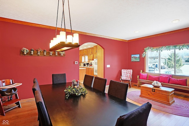 dining room with ornamental molding, hardwood / wood-style floors, and a textured ceiling