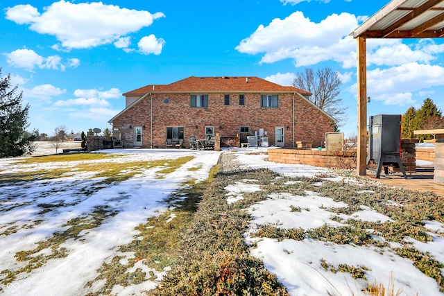 view of snow covered rear of property