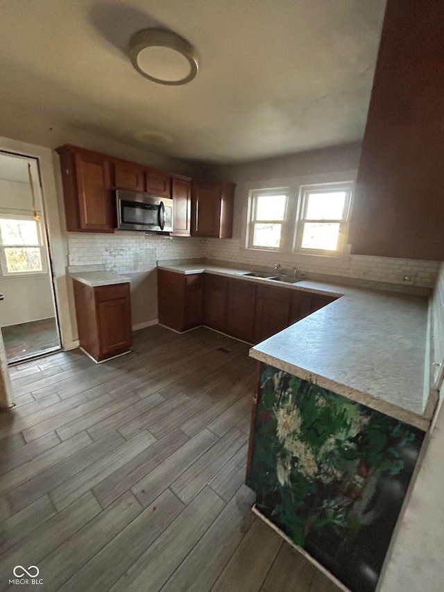 kitchen with tasteful backsplash, sink, and light hardwood / wood-style floors