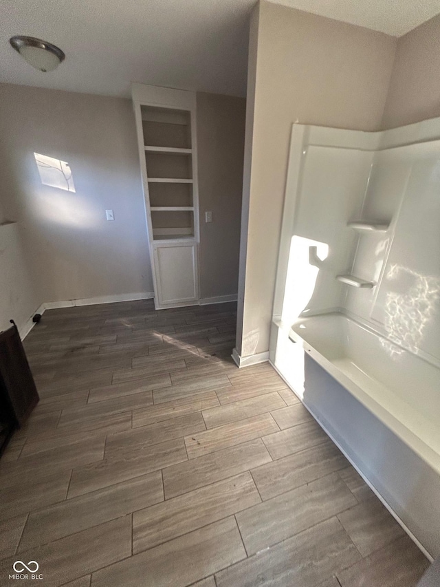 bathroom featuring built in features and a bathtub