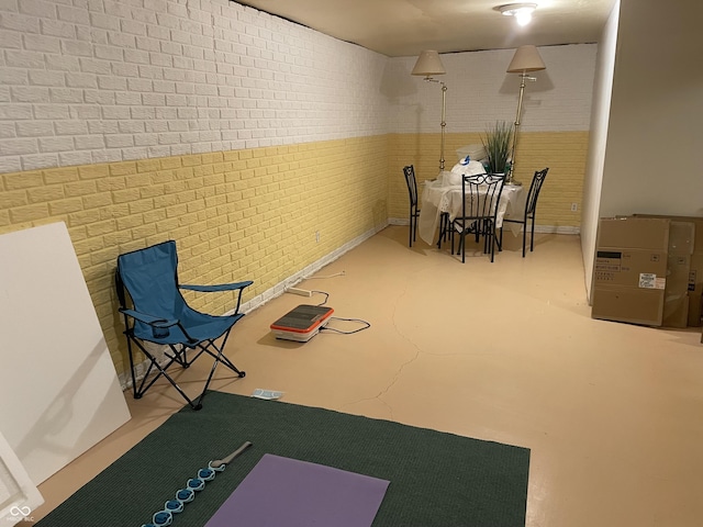 interior space featuring concrete flooring and brick wall