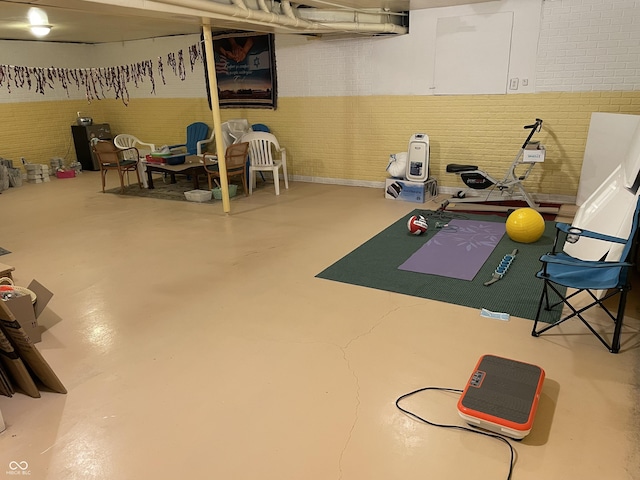 workout room featuring brick wall