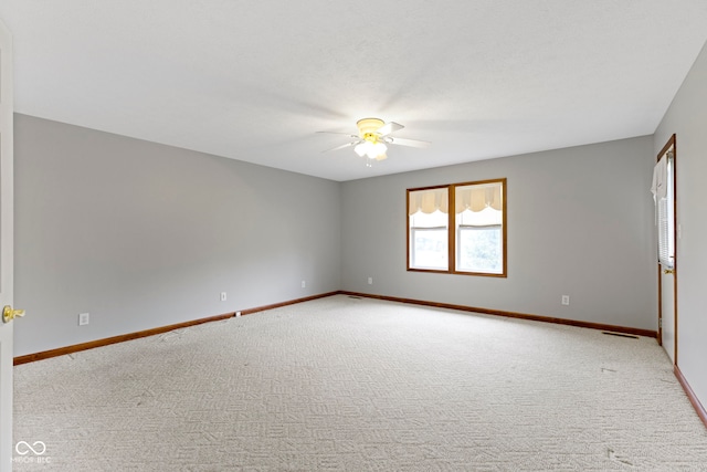 carpeted spare room featuring ceiling fan