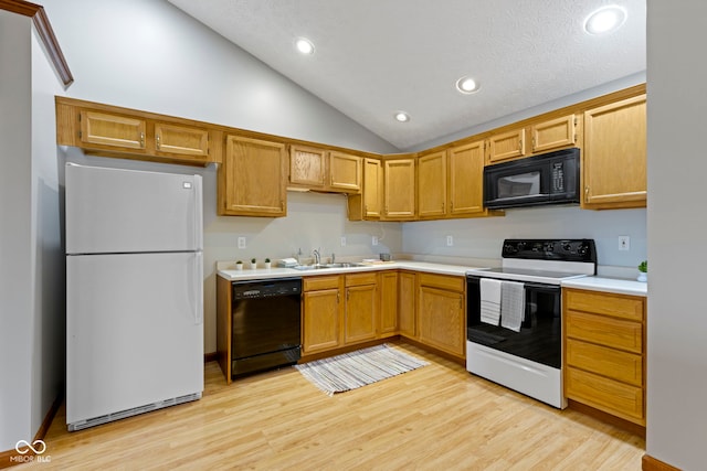 kitchen featuring vaulted ceiling, sink, light hardwood / wood-style flooring, and black appliances