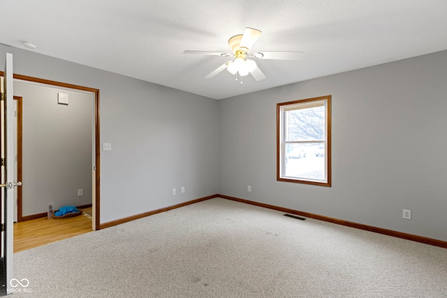 empty room with light colored carpet and ceiling fan