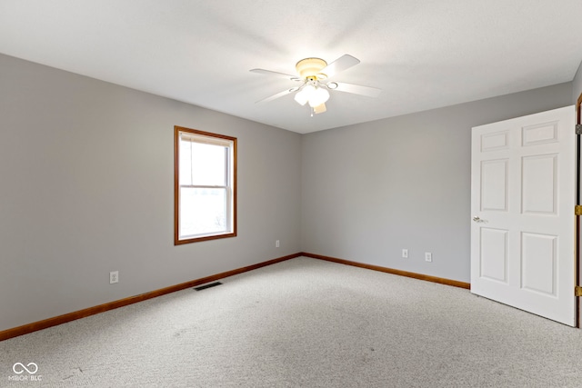 carpeted spare room with ceiling fan