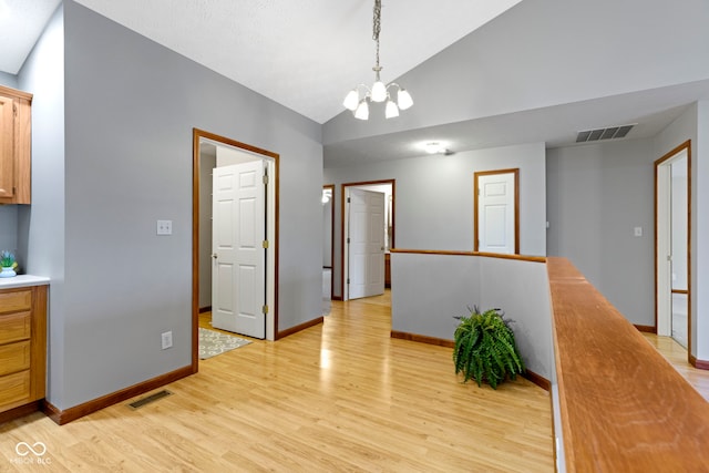 dining room with lofted ceiling, an inviting chandelier, and light hardwood / wood-style flooring