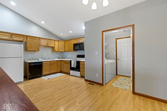 kitchen featuring lofted ceiling, separate washer and dryer, light hardwood / wood-style floors, and black appliances