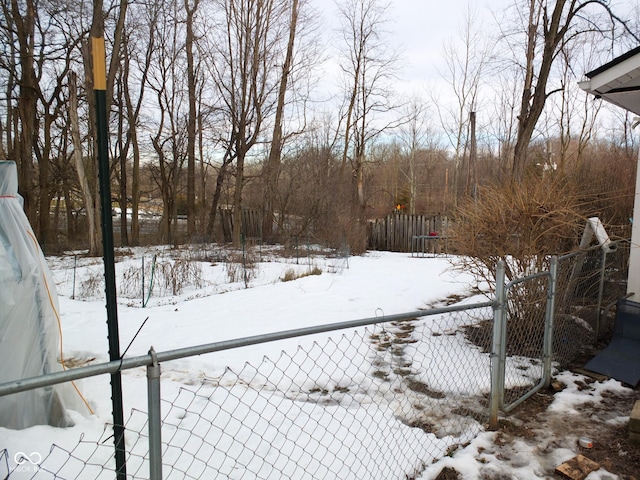 yard covered in snow featuring fence