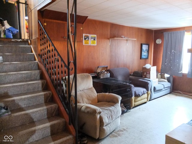 living area featuring wooden walls and stairway