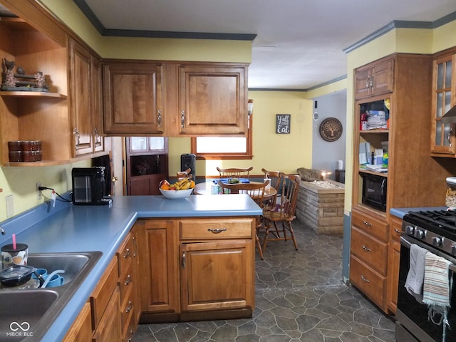 kitchen featuring black microwave, a peninsula, brown cabinets, stainless steel gas stove, and open shelves