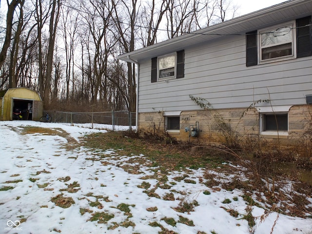 snow covered property with a storage shed