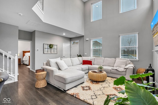 living room with a wealth of natural light and dark wood-type flooring