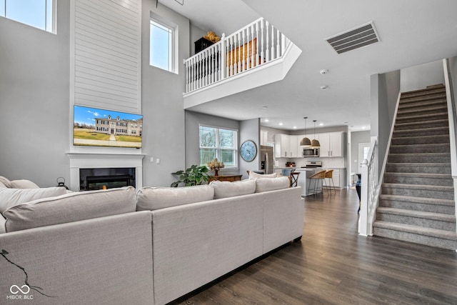 living room with dark hardwood / wood-style floors and a high ceiling