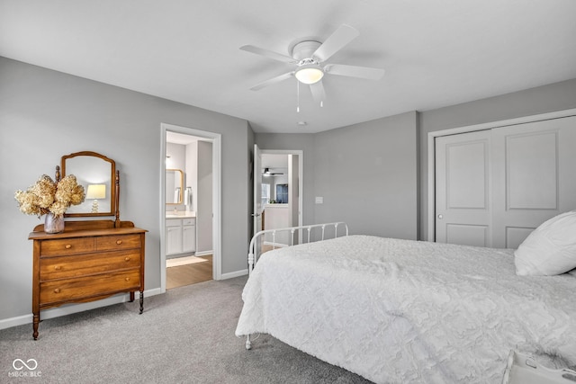 carpeted bedroom with ensuite bathroom, ceiling fan, and a closet