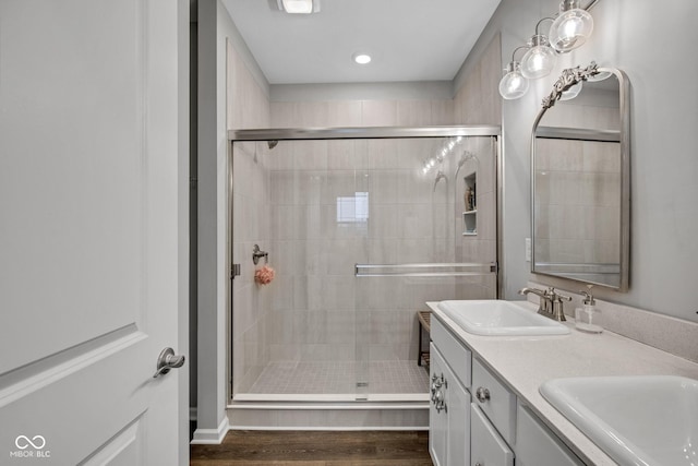 bathroom featuring hardwood / wood-style flooring, vanity, and a shower with shower door