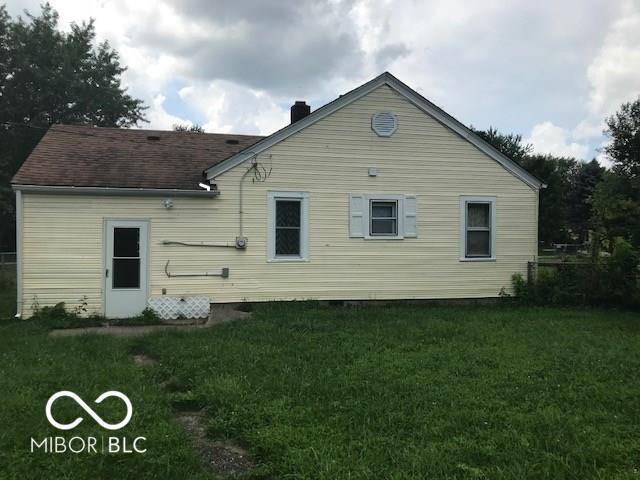 back of house featuring a lawn