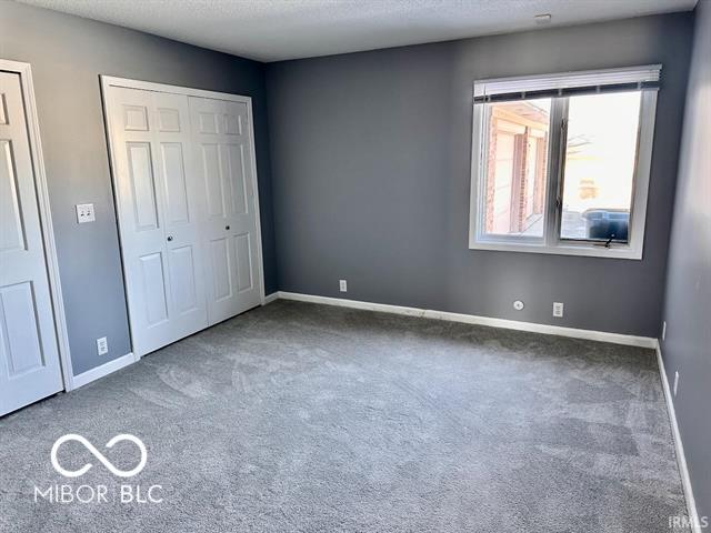 unfurnished bedroom with carpet floors and a textured ceiling