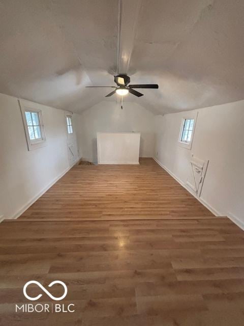 additional living space with ceiling fan, dark hardwood / wood-style floors, and vaulted ceiling