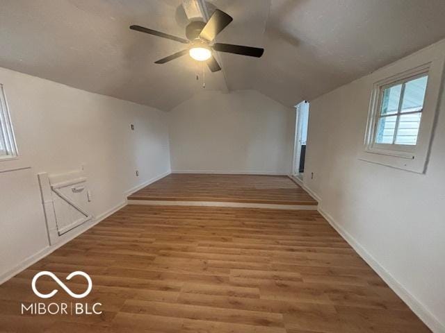 additional living space featuring wood-type flooring, vaulted ceiling, and ceiling fan