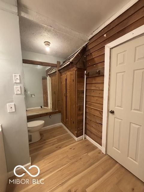 bathroom featuring hardwood / wood-style floors, a textured ceiling, and toilet