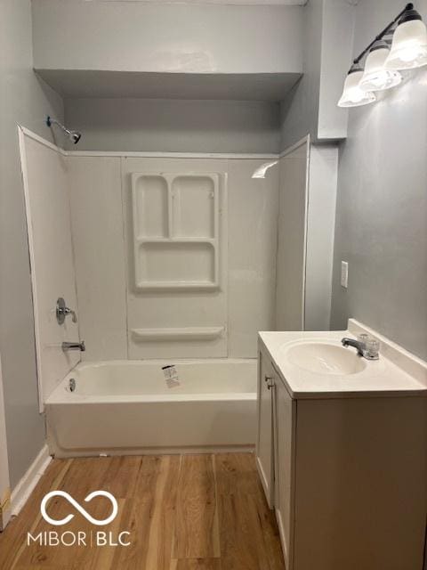 bathroom featuring wood-type flooring, bathing tub / shower combination, and vanity