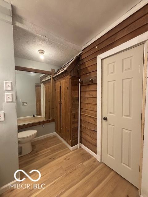 bathroom with toilet, hardwood / wood-style floors, and a textured ceiling