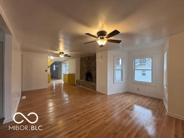 unfurnished living room featuring wood-type flooring, a fireplace, and ceiling fan