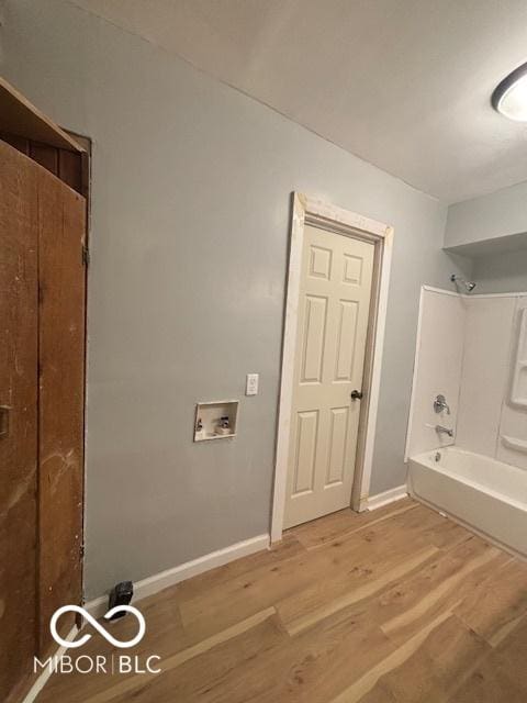 bathroom with shower / bath combination and hardwood / wood-style floors