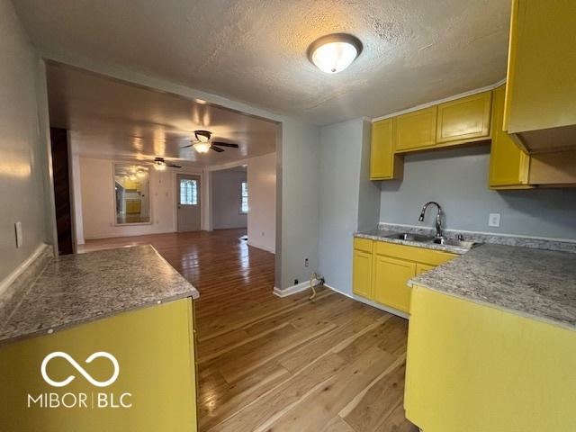 kitchen featuring sink, light hardwood / wood-style flooring, light brown cabinets, a textured ceiling, and ceiling fan