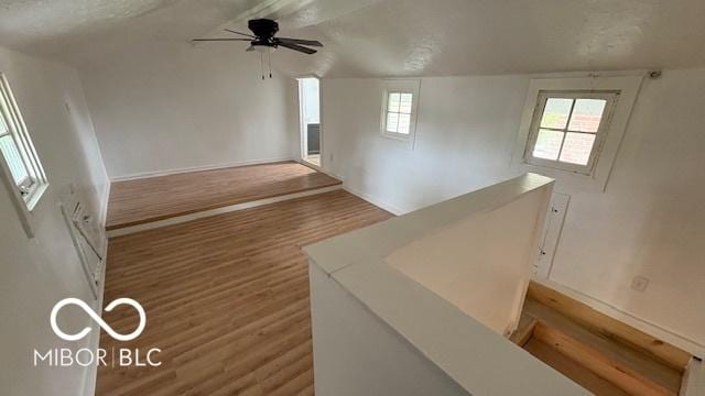 empty room featuring baseboards, a ceiling fan, and wood finished floors