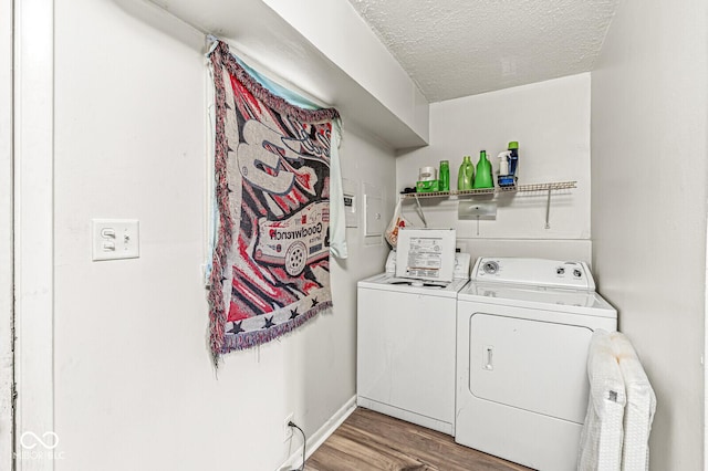 washroom featuring hardwood / wood-style floors, a textured ceiling, and washer and clothes dryer