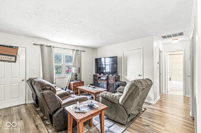 living room with light hardwood / wood-style flooring and a textured ceiling