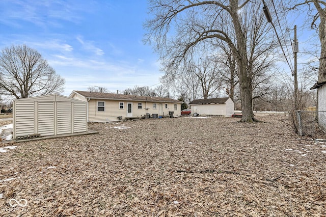 rear view of house with a storage shed