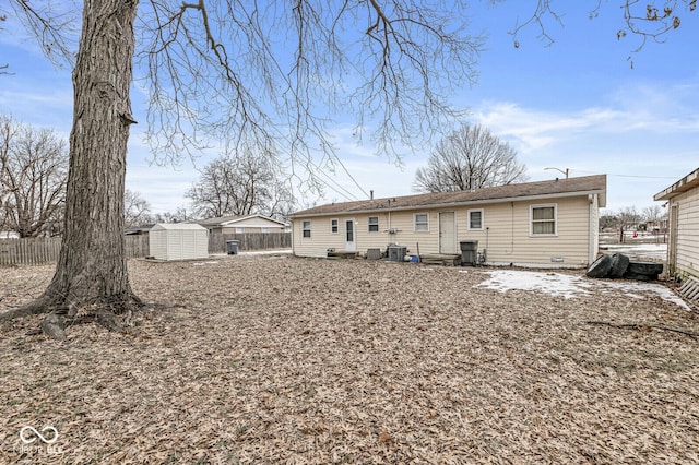 rear view of house featuring central AC unit and a shed