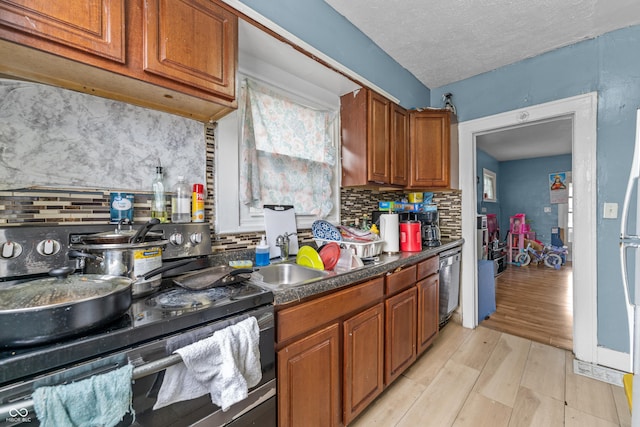 kitchen with dishwashing machine, backsplash, range with electric cooktop, a textured ceiling, and light wood-type flooring