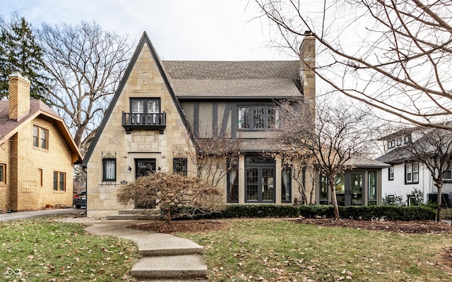 english style home featuring a front yard