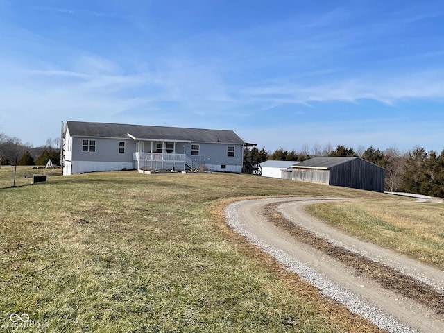 view of front of property featuring an outbuilding, covered porch, and a front lawn