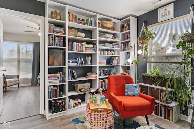 sitting room with hardwood / wood-style flooring and ceiling fan