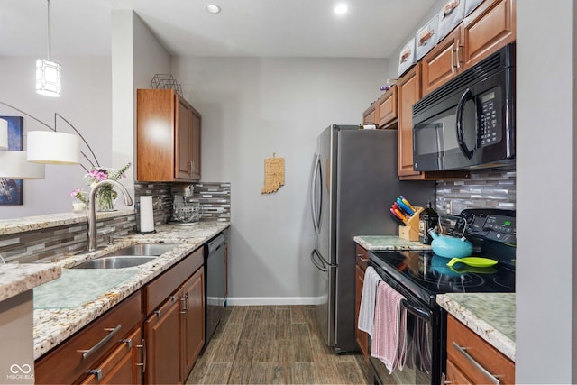 kitchen with dark hardwood / wood-style floors, pendant lighting, sink, backsplash, and black appliances