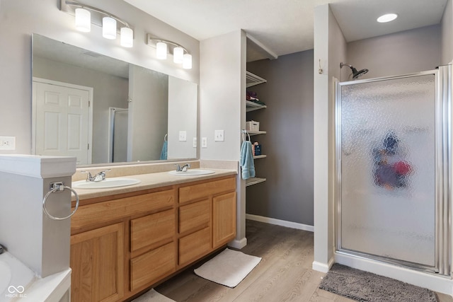 bathroom with walk in shower, vanity, and hardwood / wood-style flooring