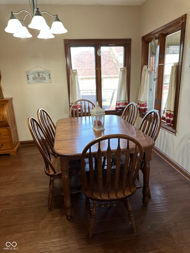 dining room with dark wood-type flooring and a chandelier