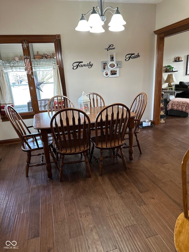 dining room with dark wood-type flooring and a notable chandelier