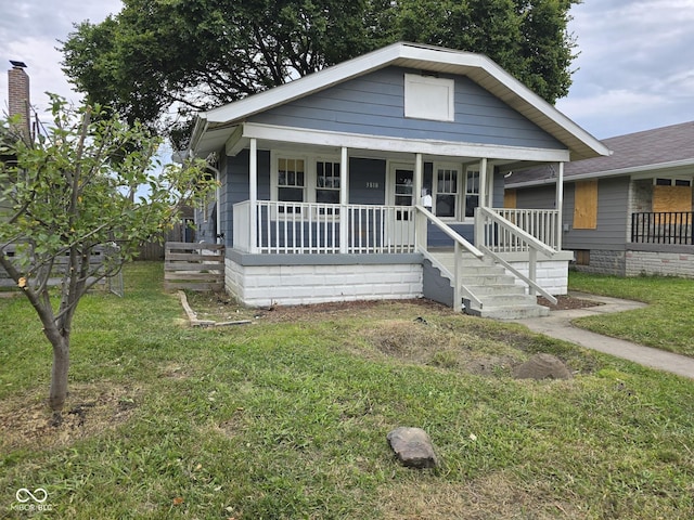 bungalow-style home featuring a front yard and covered porch